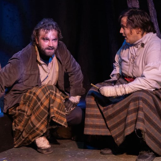 Two people seated and in conversation.