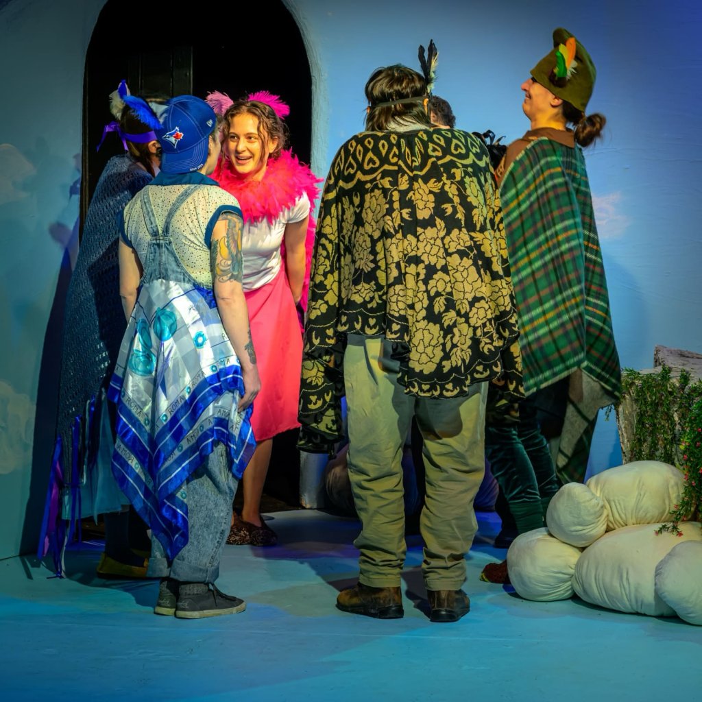 A group of people dressed up as birds talk to each other in a circle