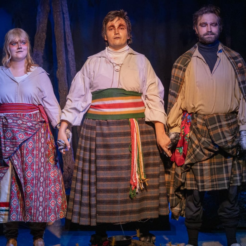Three people holding hands during curtain call.